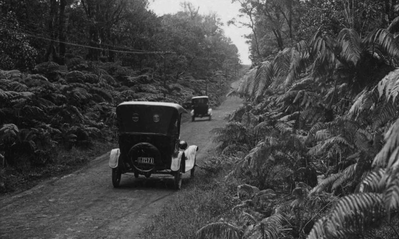 Archival photo of old car driving through Volcano on dirt road.